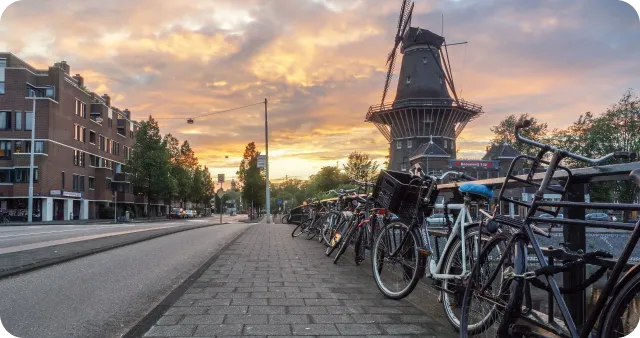 Amsterdam with a mill and bikes close to a canal on a bridge